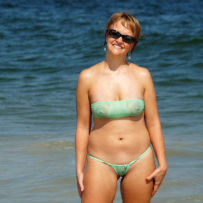 milf smiling on the beach fully exposed in her see through bikini